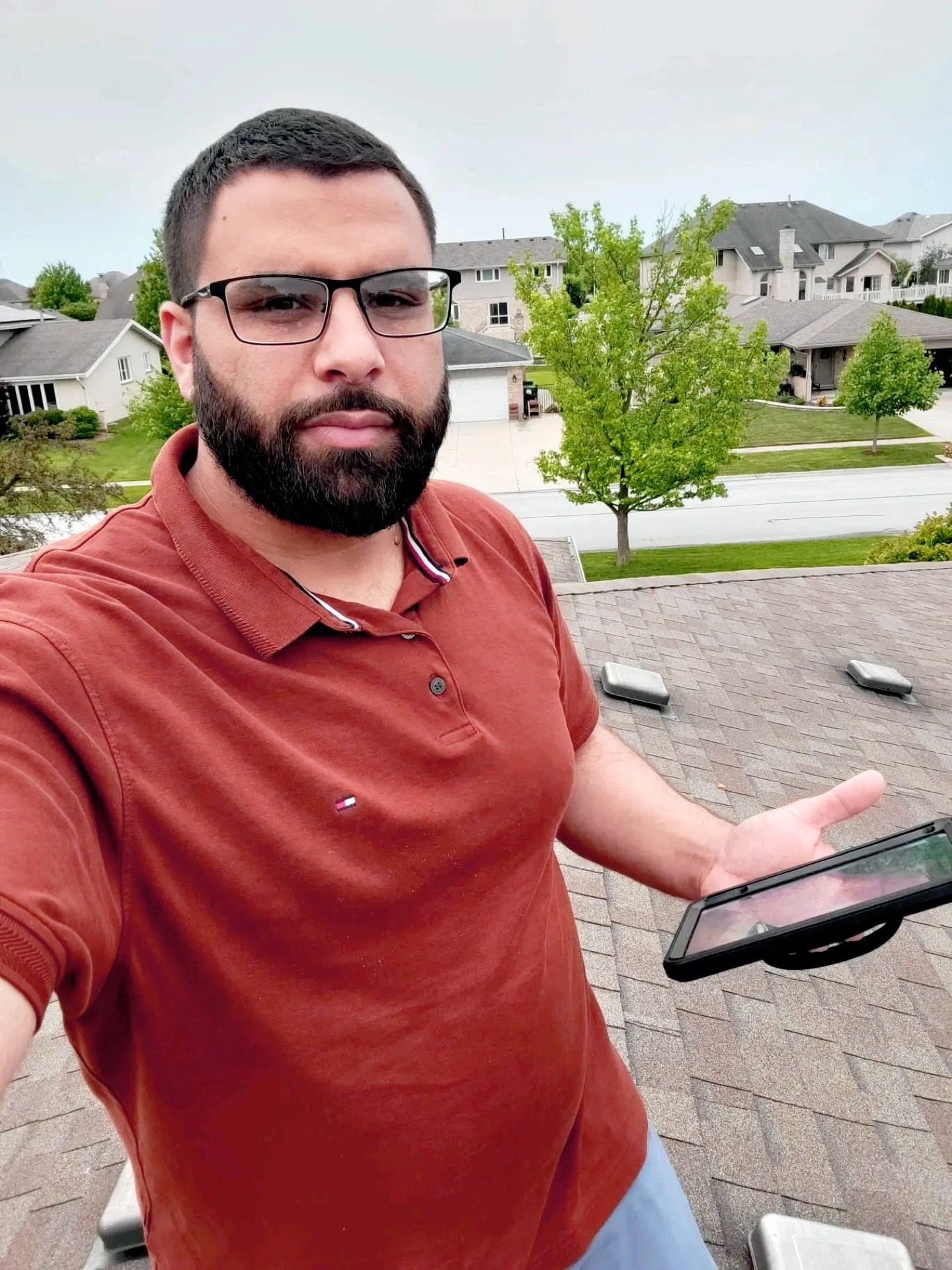 Islam Jaber on a roof during an inspection, holding his flashlight